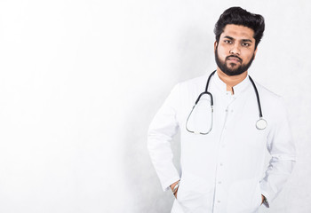 Poster - Handsome young doctor in a white coat with a stethoscope. Health care concept.