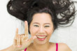 © Nutt - Closeup portrait of happy asian women  lying on ground with black long hair. acting smile, fun,