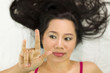 © Nutt - Closeup portrait of happy asian women  lying on ground with black long hair. acting smile, fun,
