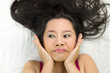 © Nutt - Closeup portrait of happy asian women  lying on ground with black long hair. acting smile, fun,