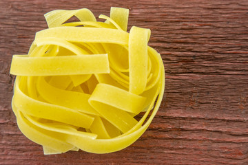 Wide cooking noodles on a wooden base