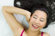 © Nutt - Closeup portrait of happy asian women  lying on ground with black long hair.