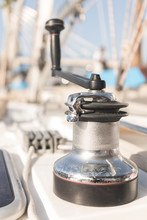 Winch With Handle For Hoisting Rope On Boat In Sunny Day On Blurred Background