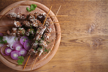 Wall Mural - Beef liver on skewers with sesame seeds on wooden tray. Liver Kebab, kabob. room for text