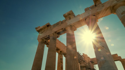 Sun shines between the columns of the Parthenon at the Acropolis in Athens, Greece