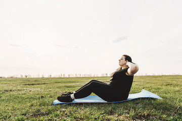 Wall Mural - Weight losing, outdoor activity, exercising, healthy lifestyle. Overweight woman doing sit-ups on exercise mat outdoors.