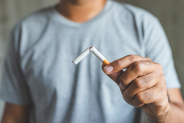 Close up male hand holding a cigarette.