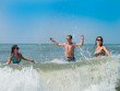 © dina777 - Young people have fun swimming and splashing in the waves of the sea on a hot day.