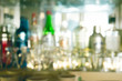 © gile68 - coaster under glass on blurred bar background. Empty the top of wooden table with blurred counter bar and bottles Background