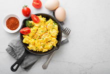 Scrambled Eggs On Skillet Over Gray Stone Background.