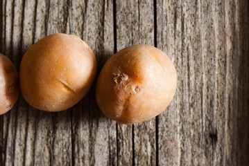 Canvas Print - petite potatoes on rustic wood table background