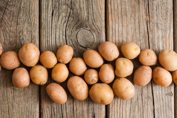 Canvas Print - petite potatoes on rustic wood table background