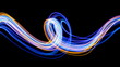 Light painting photography, blue and gold loops and swirls of vibrant color, long exposure photo of fairy lights against a black background