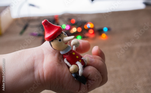Wooden Pinocchio doll sitting in hand