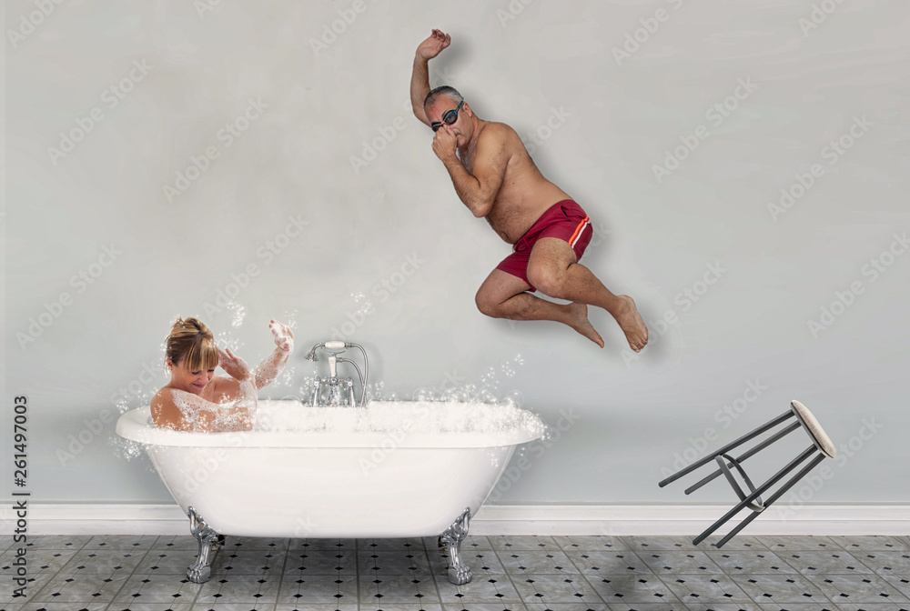 marito si tuffa nella vasca mentre la moglie si rilassa facendo un bagno caldo - obrazy, fototapety, plakaty 
