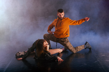 The beautiful female dancer is laying on the floor while her male partner performs an exotics unique modern art moves over her.