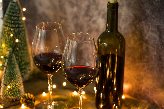 Fototapete - Red wine on table with Christmas lights on the background