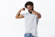 © Cookie Studio - Studio shot of confident self-satisfied african american sportsman in glasses with beard and curly hair pointing at camera with disdain frowning showing masculine biceps, working out, challenging