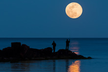 Two Anglers Are Fishing In The Mediterranean And In The Background The Full Moon Rises And Is Reflected In The Sea