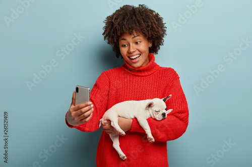 Positive Dark Skinned Woman Laughs Happily Poses At Mobile