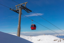 A Red Cable Car Cabin In The Winter Sports Region At Granada In The Sierra Navada In Front Of Blue Sky With Clouds