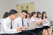 © kwanchaichaiudom - Teenage Students in uniform working with laptop in classroom