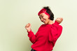 © luismolinero - Young woman with red sweater enjoy dancing while listening to music at a party