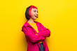 Young woman with pink hair over yellow wall happy and smiling