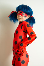 Corby, United Kingdom. March 12, 2019 - Little Girl In Ladybug Myraculous Cosplay Costume. Superhero Ladybug With Blue Twig, Isolated.
