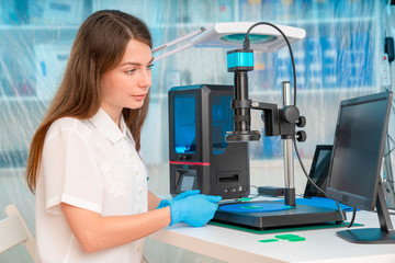 Canvas Print - Woman worker in control of Resin LCD / DLP / SLA 3D Printer in technology lab