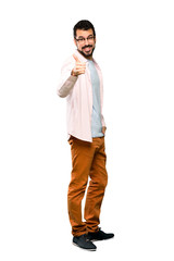 Full-length shot of Handsome man with beard with thumbs up because something good has happened over isolated white background