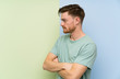 © luismolinero - Redhead man over colorful background standing and looking side