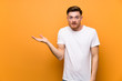 © luismolinero - Redhead man over brown wall making doubts gesture