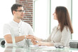 © yurolaitsalbert - businessman and businesswoman shaking hands while sitting at the Desk.
