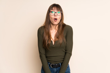 Young woman on ocher background with surprise facial expression