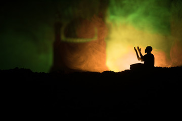 Wall Mural - Silhouette of mosque building on toned foggy background. Ramadan Kareem background. Mosque at sunset. Praying people