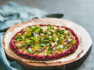 beetroot pizza crust with fresh swiss chard or mangold, beetroot leaves. Ideas and recipes for vegan snack.Egg-free pizza crust with chia seeds and wholegrain brown rice flour. Copy space. Shallow DOF