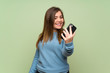 © luismolinero - Young girl over green wall making a selfie