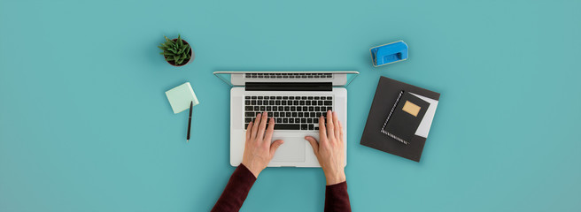 Man typing on laptop. Top view on office desk with copy space.