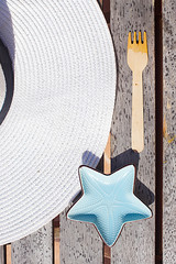 Hat, fork and plate in the form of a starfish on a wooden table