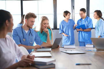 Group of smart medical students with gadgets in college