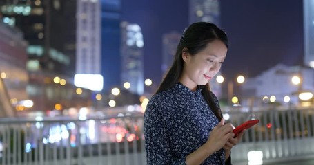 Wall Mural - Woman read on smart phone in city at night