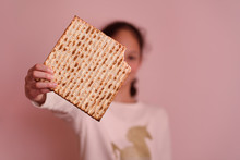 Portrait Of The Cute Teenager Girl Holding Matzah. Jewish Child Eating Matzo Unleavened Bread In Jewish Holidays Passover.