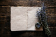 Dried lavender flower branch and a blank aromatherapy recipe book mock up on a wooden table background with copy space. Herbal medicine concept.