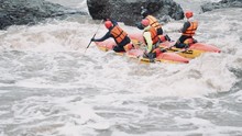 Rafting Team Descending Raging Rapids In Mountain River With Paddles Splashing In Water In Slow Motion. Close-up