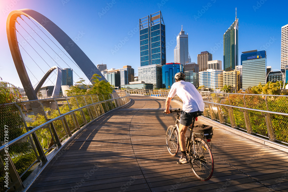 A man cycling on an elizabeth bridge in Perth city - obrazy, fototapety, plakaty 