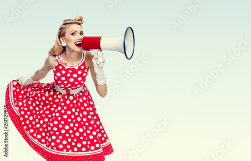 happy woman holding megaphone, dressed in pin-up style red dress Tableau sur Toile