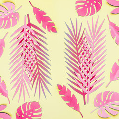 Wall Mural - Pink tropical leaves flat lay on yellow background. Creative layout. Various tropical leaves composing