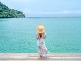 Fototapeta Pomosty - Young fashion woman relax on the seaveiw. Happy island lifestyle. The blue cloudy sky and crystal sea of tropical beach. Vacation at Paradise. travel to Maldives islands