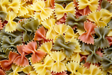 Uncooked Farfalle Tricolore Pasta background. Top view